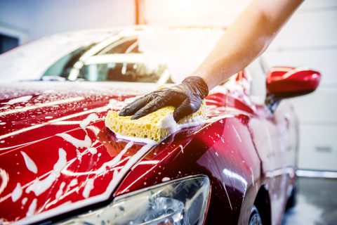 worker-washing-red-car-with-sponge-car-wash
